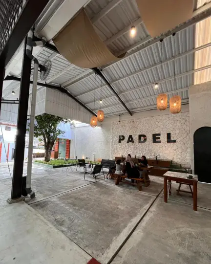 Lounge seating beside a PADEL wall